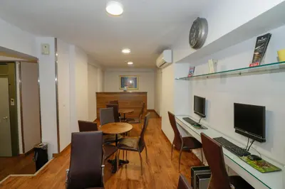 a room with a desk with a computer and chairs at Mansion Hotel in Athens