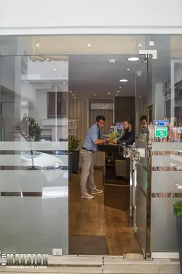 two men standing at a counter in an office at Mansion Hotel in Athens