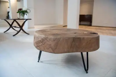 a tree stump coffee table with black legs and a wooden top at AD Athens Luxury Rooms & Suites in Athens