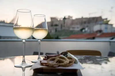 two glasses of white wine sitting on a table at AD Athens Luxury Rooms & Suites in Athens