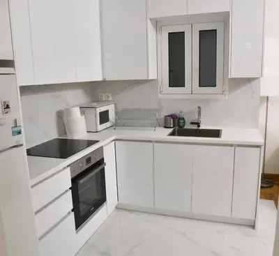 a white kitchen with white cabinets and a sink at Perfect athens in Athens
