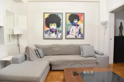 a living room with a couch and two paintings on the wall at Perfect athens in Athens