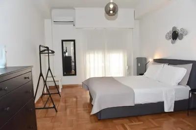 a bedroom with a bed and a dresser and a mirror at Perfect athens in Athens