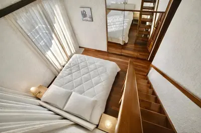 a small room with a bed and a staircase at Villa Naya by the Beach in Anavissos