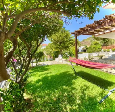 a hammock in the shade of a tree in a yard at Villa Naya by the Beach in Anavissos