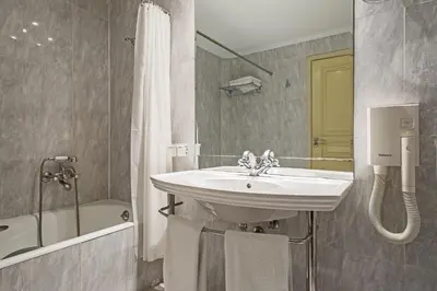 a bathroom with a sink and a bath tub and a sink at Airotel Stratos Vassilikos Hotel in Athens