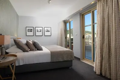 a bedroom with a bed and a large window at Airotel Stratos Vassilikos Hotel in Athens