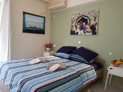 a bedroom with a bed with a striped comforter at Sounio Palea Heaven in Palaiá Fókaia