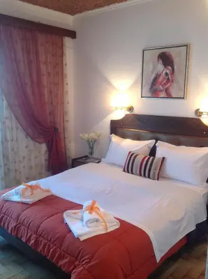 a hotel room with a bed with towels on it at Angela Hotel in Agia Marina Aegina