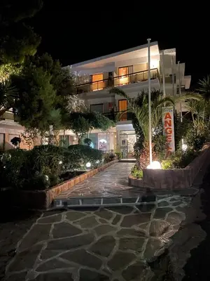 a building at night with a walkway in front at Angela Hotel in Agia Marina Aegina