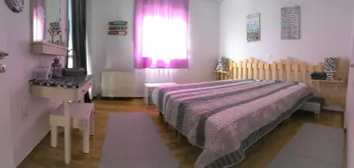 a bedroom with a bed and a table and a window at Your Home in Athens