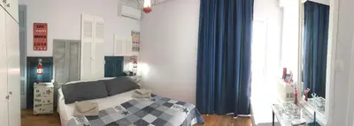 a bedroom with a bed and blue drapes at Your Home in Athens