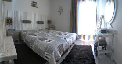 a bedroom with a bed and a table and a window at Your Home in Athens
