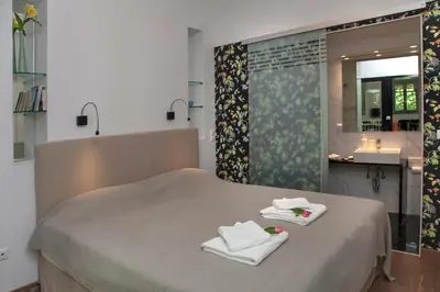 a bedroom with a bed with towels and a sink at Tripodon Plaka In the shade of Acropolis by GHH in Athens