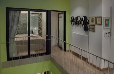 a staircase in a room with green walls and a window at Tripodon Plaka In the shade of Acropolis by GHH in Athens