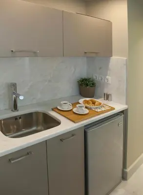 a kitchen counter with a sink and a plate of food at Tripodon Plaka In the shade of Acropolis by GHH in Athens
