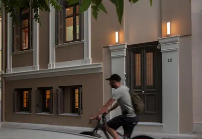 a man riding a bike in front of a building at Tripodon Plaka In the shade of Acropolis by GHH in Athens