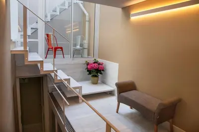 a room with a staircase and a chair and flowers at Tripodon Plaka In the shade of Acropolis by GHH in Athens