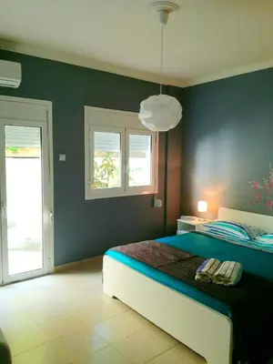 a bedroom with a bed with a blue wall at Charilaou Trikoupi Flat in Athens