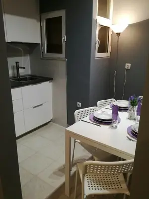 a kitchen with a white table and chairs and a sink at Charilaou Trikoupi Flat in Athens