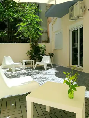 a patio with white furniture and a table and chairs at Charilaou Trikoupi Flat in Athens