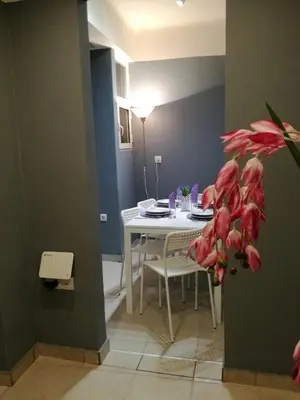 a dining room with a table and a white table and chairs at Charilaou Trikoupi Flat in Athens