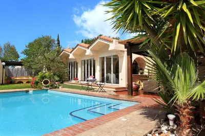 a swimming pool in front of a house at Oasis Pool House by GHH in Lagonissi