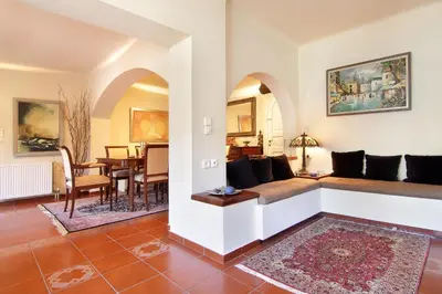 a living room with a couch and a dining room at Oasis Pool House by GHH in Lagonissi