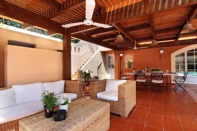 a living room with wicker furniture and a kitchen at Oasis Pool House by GHH in Lagonissi