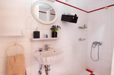 a white bathroom with a sink and a mirror at Oasis Pool House by GHH in Lagonissi