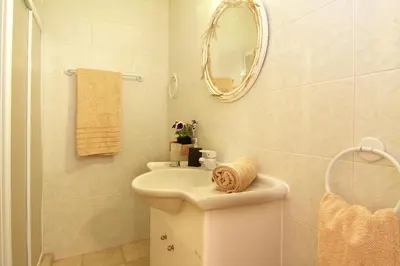 a white bathroom with a sink and a mirror at Oasis Pool House by GHH in Lagonissi