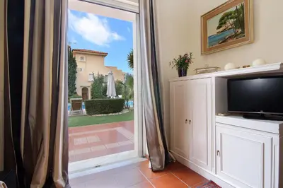 a living room with a tv and a sliding glass door at Oasis Pool House by GHH in Lagonissi