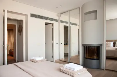a bedroom with a fireplace and a bed with mirrors at Unique Acropolis View in Athens
