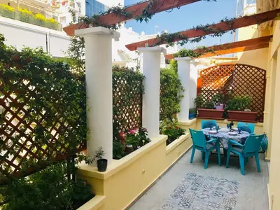 a patio with a table and chairs and a fence at Oasis veranda under columns.Kolonaki embassy area. in Athens