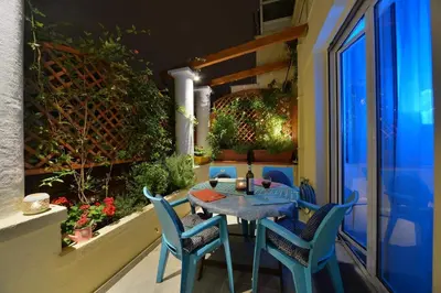 a patio with a table and chairs on a balcony at Oasis veranda under columns.Kolonaki embassy area. in Athens