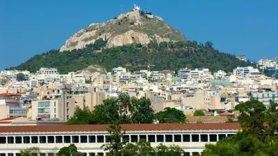 a view of a city with a mountain in the background at Oasis veranda under columns.Kolonaki embassy area. in Athens
