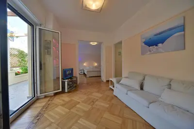 a living room with a white couch and a television at Oasis veranda under columns.Kolonaki embassy area. in Athens