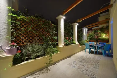 a patio with plants and a table and chairs at Oasis veranda under columns.Kolonaki embassy area. in Athens