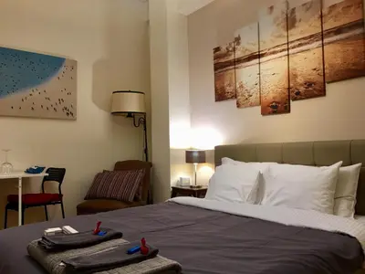a bedroom with a bed and a table with a chair at Elegant Studio in Kolonaki-Top Location! in Athens