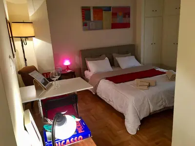 a bedroom with two beds and a table with a lamp at Elegant Studio in Kolonaki-Top Location! in Athens