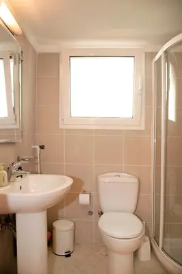 a bathroom with a toilet and a sink and a window at Elegant Studio in Kolonaki-Top Location! in Athens