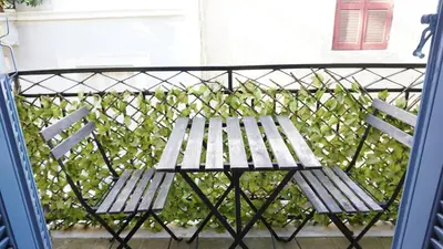 a wooden bench sitting on top of a balcony at Athenian House in Plaka Villa by Athenian Homes in Athens