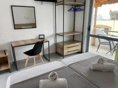 a bedroom with a bed and a desk and a chair at Georgina in Agia Marina Aegina