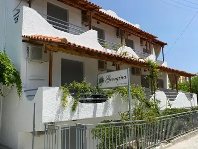 a white building with a sign in front of it at Georgina in Agia Marina Aegina