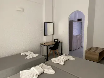 a room with two beds and a desk and a chair at Georgina in Agia Marina Aegina