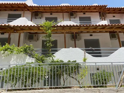a white house with a fence in front of it at Georgina in Agia Marina Aegina