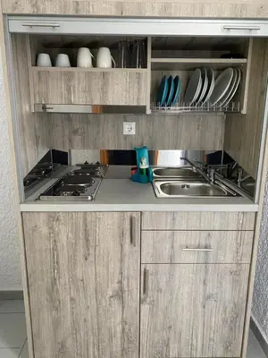 a small kitchen with a sink and a stove at Georgina in Agia Marina Aegina