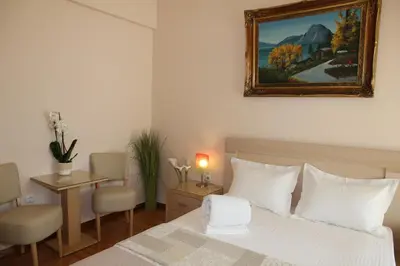 a bedroom with a white bed and a painting on the wall at Olga's Studio in Athens