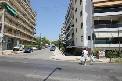 a woman and a child crossing a city street at Olga's Studio in Athens