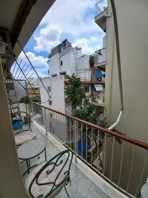 a balcony with tables and chairs on a building at Olga's Studio in Athens